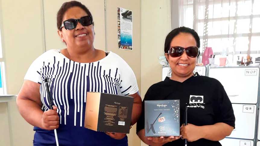 As duas associadas da ADEVIC, Regina e Kelly, estão sorrindo e segurando cada uma a sua caixa de panetone. 