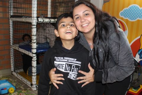 Miguel Davi, menino associado da ADEVIC, e sua mãe Patrícia posam juntos para uma foto com muitos sorrisos