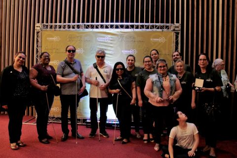 Equipe da ADEVIC posa para foto durante o evento. Estão todos em pé, sorrindo.