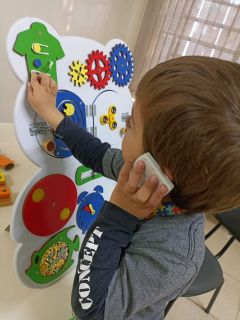 Criança brincando com gravuras infantis na parede